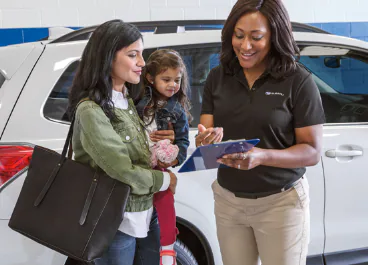 A mother and child talking to a Subaru Service Representative.